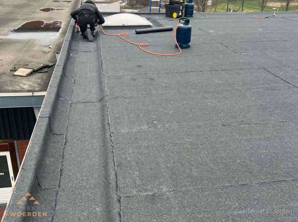 Dakdekker repareert bitumen dakbedekking op groot plat dak in Woerden Dakdekker repareert bitumen dakbedekking op groot plat dak in Woerden