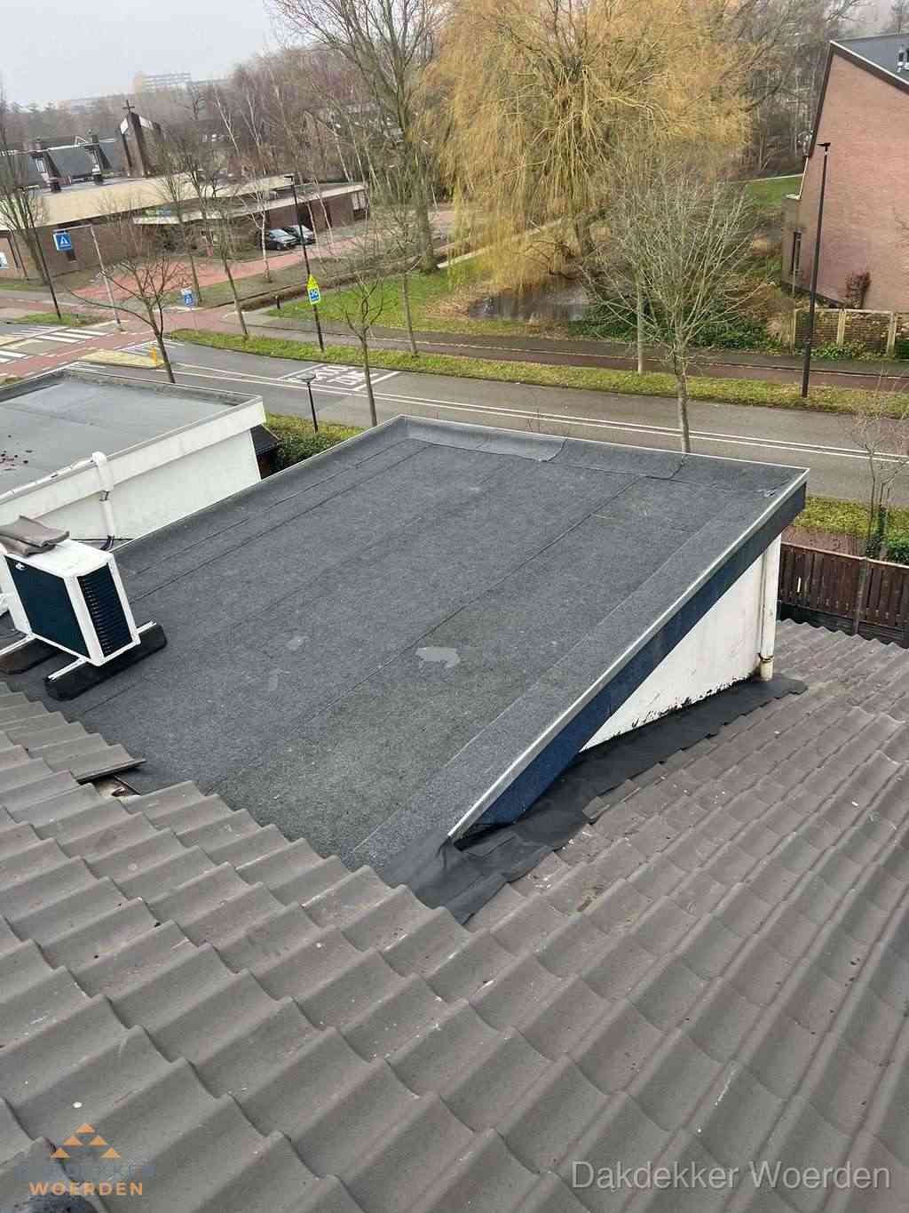 Plat dak met bitumen dakbedekking naast schuin pannendak in Woerden Plat dak met bitumen dakbedekking naast schuin pannendak in Woerden